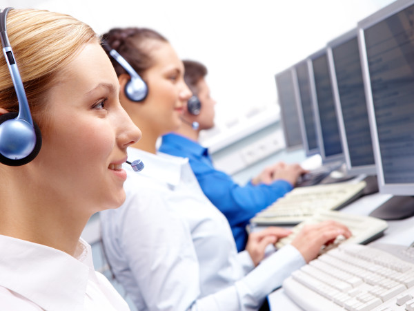 Row of telephone operators looking at the monitor and working